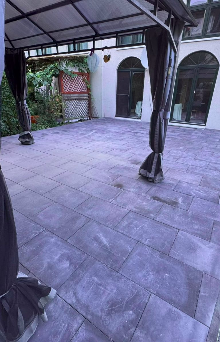 Neu gepflasterte Terrasse eines Gartenmücke-Projekts mit überdachtem Sitzbereich